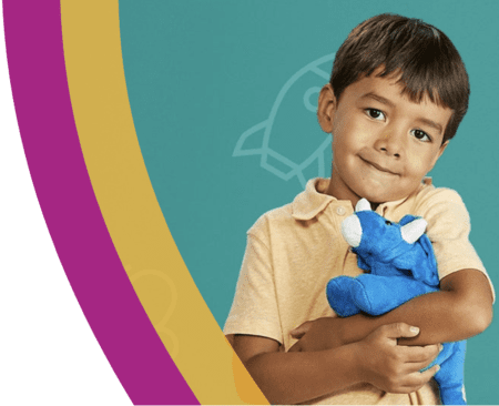 A young boy in a yellow shirt holds a blue stuffed animal, smiling gently against a teal background adorned with a faint dinosaur outline. On the left, curved bands in purple, yellow, and white add vibrancy. His joyful expression reflects the spirit of Austin Gives Miles, supporting children and charities alike. Austin Marathon Half Marathon & 5K